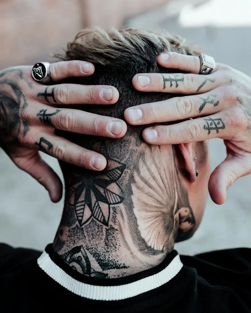 Tatuagem ornamental na nuca e mãos tatuadas