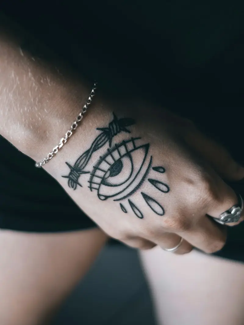 Olho geométrico tatuado na mão